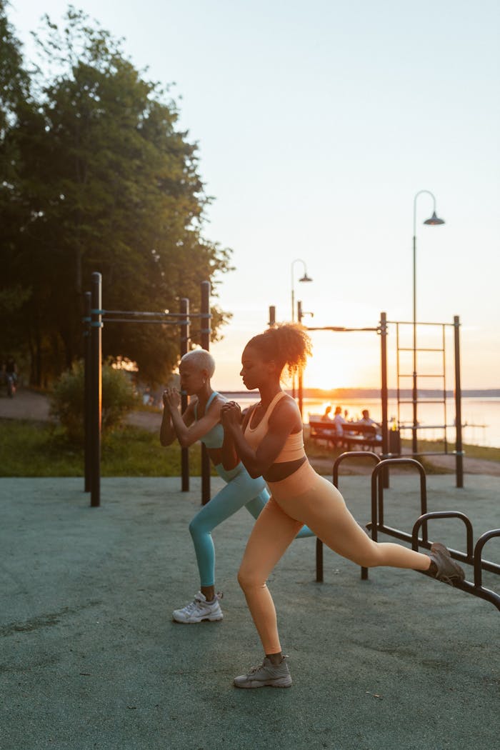 about-01 Two women exercising outdoors at sunset, demonstrating fitness and health.